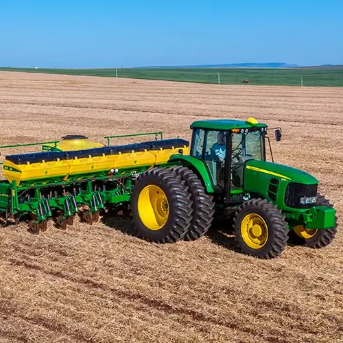 Trator equipado com implementos agrícolas, elegível ao FINAME, operando em uma lavoura para otimizar a produção.